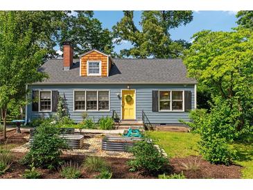 Charming home featuring a landscaped front yard with garden beds and a bright yellow front door at 131 Lively St, Norcross, GA 30071