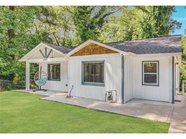 Charming single-story home boasts a well-manicured lawn and delightful curb appeal with detailed trim and an inviting egg chair at 1497 Eason Nw St, Atlanta, GA 30314