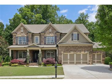 Beautiful two-story brick home with lush landscaping, a welcoming front porch, and three-car garage at 1136 Garner Creek At Parkview Sw Dr, Lilburn, GA 30047