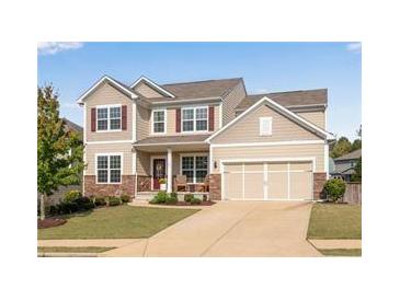 Charming two-story home featuring a manicured lawn, neutral siding, and attached two-car garage at 704 Woodbridge Dr, Woodstock, GA 30188