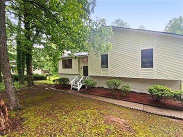 Charming exterior of a home with light siding, surrounded by lush trees and landscaping at 2325 Sebring Sw Ct, Marietta, GA 30064