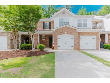 Charming brick townhome with a well-manicured lawn and a two-car garage, creating an inviting curb appeal at 3453 Dianthus Ln, Lawrenceville, GA 30044