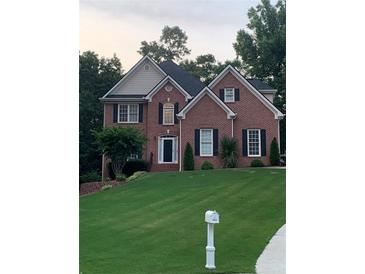 Charming brick home with a well-manicured lawn and classic architectural details at 1502 La Fayette Pl, Loganville, GA 30052