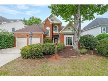 Charming brick home featuring a two-car garage, well-maintained landscaping, and traditional architectural details at 1996 Wellesley Trce, Atlanta, GA 30338