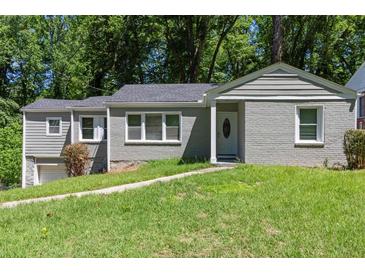 Charming single-story home with gray brick and siding, complemented by a lush green lawn at 2025 Venetian Sw Dr, Atlanta, GA 30311