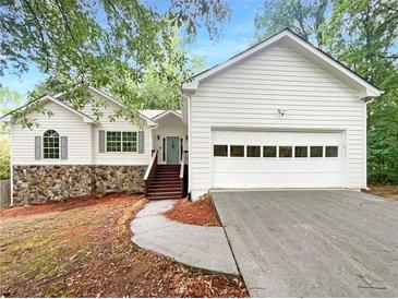 Charming one-story home with white siding, stone accents, and attached garage at 3458 Natalie Ct, Loganville, GA 30052