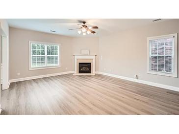 Bright living room features a fireplace, ceiling fan, and hardwood floors at 300 Oregan Trl, Marietta, GA 30080