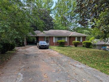 Traditional brick home with manicured lawn, showcasing classic curb appeal in a serene, tree-lined setting at 2985 Laguna Dr, Decatur, GA 30032