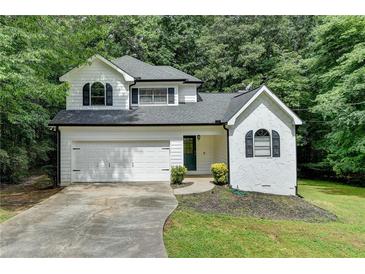 Charming two-story home with a well-manicured lawn, garage, and classic architectural details at 4278 Trotters Ln, Auburn, GA 30011