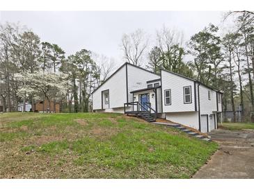 Charming renovated two-story home with a modern color scheme, landscaped yard, and inviting blue front door at 783 Lost Creek Cir, Stone Mountain, GA 30088