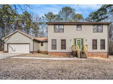 Charming two-story home with light siding, brick foundation, and a lovely green front door and matching trim at 1791 Lake George Dr, Lithia Springs, GA 30122