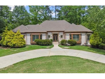 Elegant one-story home features a circular driveway, manicured lawn, and lush landscaping at 194 Sentinel Se Pl, Marietta, GA 30067