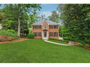 Charming two-story brick home with a manicured lawn and mature trees, offering classic curb appeal at 2622 Murdock Rd, Marietta, GA 30062