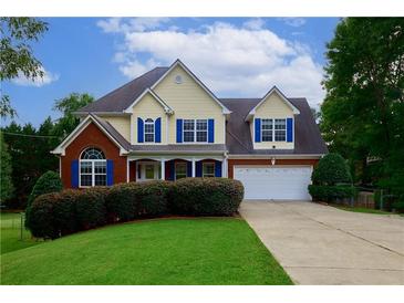 Charming two-story home with brick and siding, manicured lawn, and blue shutters on a sunny day at 1847 Oak Rd, Snellville, GA 30078