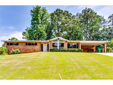 Charming brick home with a well-manicured lawn and mature trees at 2668 Kings Park Cir, Decatur, GA 30034