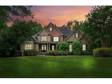 Charming two-story home with brick and stone accents, lush landscaping, and a well-manicured lawn at sunset at 2840 Astoria Ave, Cumming, GA 30040