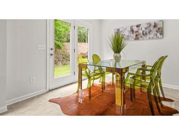 Bright dining area features stylish decor, a modern table and chairs, and natural light from the patio doors at 6571 Splitpine Ct, Atlanta, GA 30349