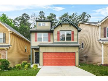 Charming two-story home boasts a red garage door, green trim and a well-manicured lawn at 6571 Splitpine Ct, Atlanta, GA 30349