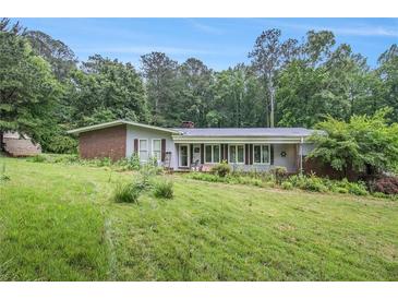 Charming single-story home with brick accents and mature trees on a spacious, gently sloping lawn at 2549 Emerald Dr, Jonesboro, GA 30236