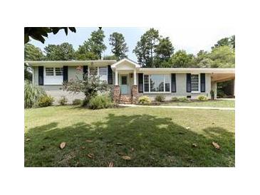 Charming ranch-style home featuring a well-manicured front yard, a covered entry, and shuttered windows at 3019 Haverford Se Ln, Marietta, GA 30067