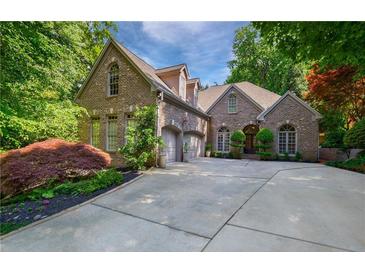 Charming brick home boasts a two-car garage, mature landscaping, and a beautifully paved driveway at 1255 Beech Haven Ne Rd, Atlanta, GA 30324