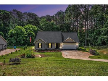 Charming single-story home with a lush green lawn and mature trees in a serene, wooded setting at 267 Rocky Point Rd, Covington, GA 30014