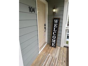 Inviting front entryway with a welcome sign, warm lighting, and a well-maintained wooden porch at 104 Abingdon Way, Atlanta, GA 30328