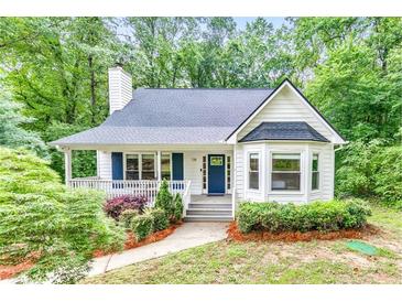Charming home featuring a landscaped front yard, inviting porch, and classic architectural details at 138 Hartwood Dr, Woodstock, GA 30189