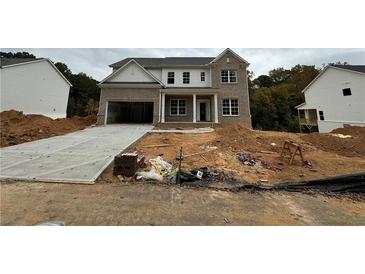 New two-story brick home featuring a two-car garage and a classic, welcoming front porch design at 314 Level Creek Rd, Sugar Hill, GA 30518