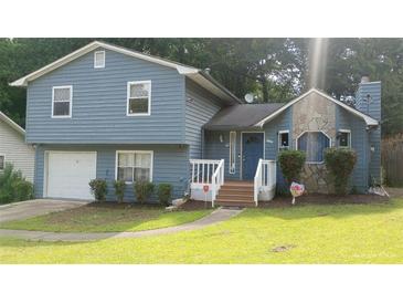 Charming two-story home with blue siding, stone accents, and a well-maintained front yard at 604 Pepperwood Ln, Stone Mountain, GA 30087