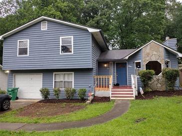 Charming two-story home with blue siding, stone accents, and a well-maintained front yard at 604 Pepperwood Ln, Stone Mountain, GA 30087