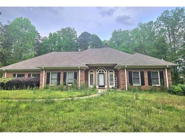 Charming one-story brick home featuring a well-manicured front yard and a welcoming entrance at 4855 West Price Rd, Sugar Hill, GA 30518