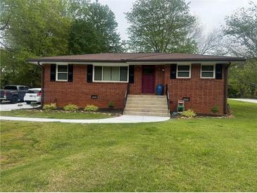 Charming brick home featuring a well-manicured lawn, new sidewalk, and a neatly landscaped front yard at 3731 Wisteria Se Ln, Smyrna, GA 30082