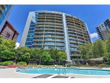Beautiful pool with building views, landscaping, and lounge chairs under a sunny blue sky at 950 W Peachtree Nw St # 911, Atlanta, GA 30309