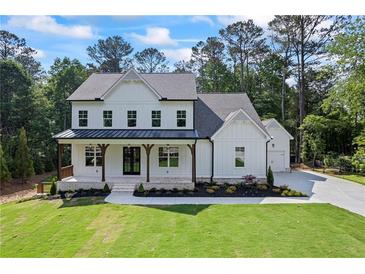 Charming two-story home featuring a welcoming front porch with wooden beams and professionally landscaped front yard at 10350 Alvin Rd, Johns Creek, GA 30022