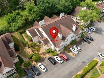 Aerial view of property with ample parking, mature trees, and architectural roof detail at 904 Bridge Se Ln, Smyrna, GA 30082