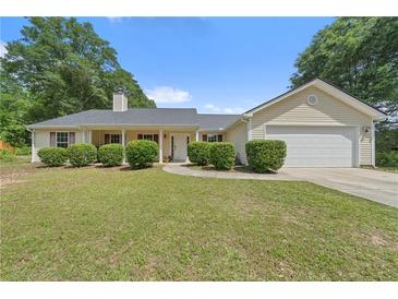 Lovely ranch-style home with a well-maintained front yard, symmetrical landscaping, and an attached garage at 100 Gum Creek Lndg, Oxford, GA 30054