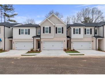 Charming townhomes feature a neutral color palette, brick accents, and individual one car garages at 504 Amethyst Way, Stockbridge, GA 30281