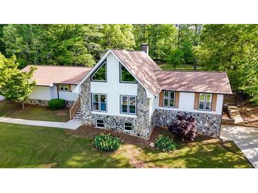 Beautiful home featuring a stone and white facade with large windows and a well-manicured lawn at 3222 Bay View Dr, Jonesboro, GA 30236