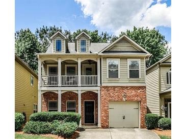 Charming two-story home boasts a brick facade, quaint balcony, and well-maintained landscaping at 334 Pin Oak Ave, Woodstock, GA 30188
