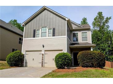 Charming two-story home features a two-car garage, neutral siding and manicured landscaping at 4605 Fourth Rail Ln, Cumming, GA 30040