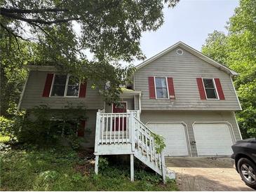 Two-story home with red shutters, white stair railing, and attached two-car garage at 554 Oak Landing Cir, Douglasville, GA 30134