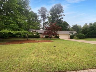Charming single story home featuring a lush front yard, mature shade trees, and a covered front porch at 2060 Devore Sw Dr, Marietta, GA 30008
