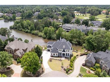 Stunning aerial view of waterfront property with lush landscaping, golf course in background at 2837 Darlington Run, Duluth, GA 30097