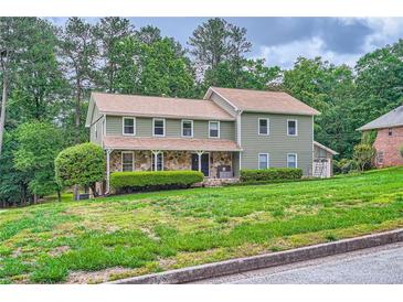 Charming two-story home with stone accents and a well-manicured front yard at 4826 Dean Sw Ln, Lilburn, GA 30047