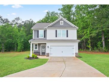 Charming two-story home with a well-manicured lawn and attached two car garage at 130 Bingley Ct, Covington, GA 30016