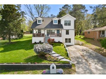 Charming renovated two-story home with manicured lawn and inviting front porch at 3412 Collier Nw Dr, Atlanta, GA 30331