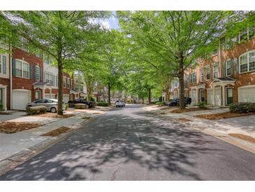 Charming townhomes line a tree-shaded street in a well-maintained community, offering a welcoming neighborhood feel at 2160 Dillard Xing, Tucker, GA 30084