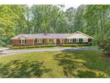 Charming brick ranch with a manicured lawn, mature trees, and a welcoming front porch at 544 W Macedonia Church Rd, Oxford, GA 30054