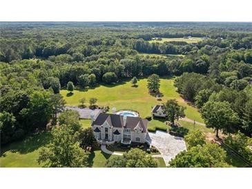 Expansive estate featuring a stately home, in-ground pool, lush landscaping, and sprawling acreage surrounded by mature trees at 1481 Highway 85 Connector, Brooks, GA 30205